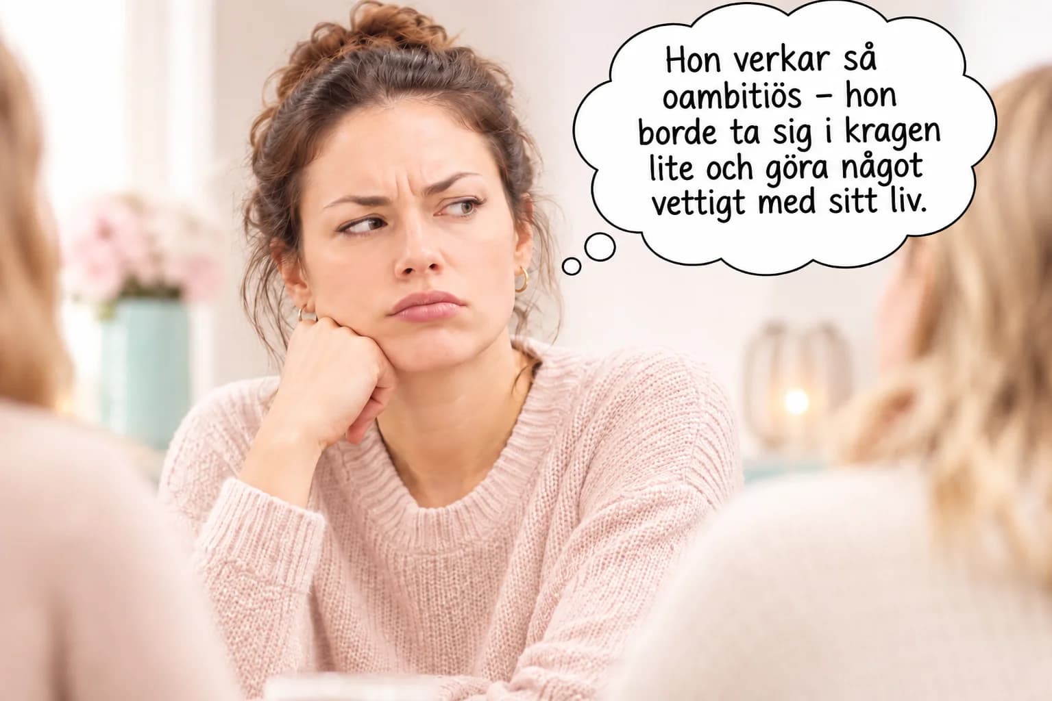 En kvinna som sitter fundersam vid ett bord och reflekterar över dömande tankar och perspektivtagning